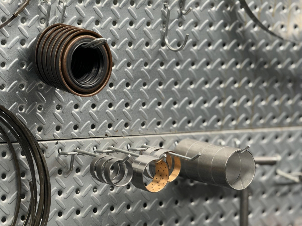 Assorted transmission components and bushing tools organized on a metal pegboard — Quantum Gear
