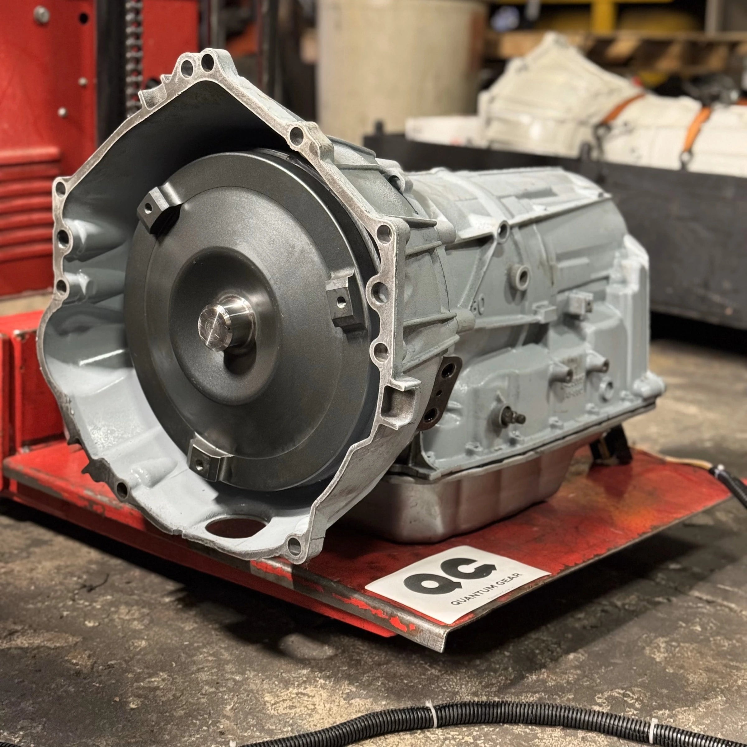 Fully remanufactured GM 6L80 transmission with torque converter, staged on a Quantum Gear testing bench.